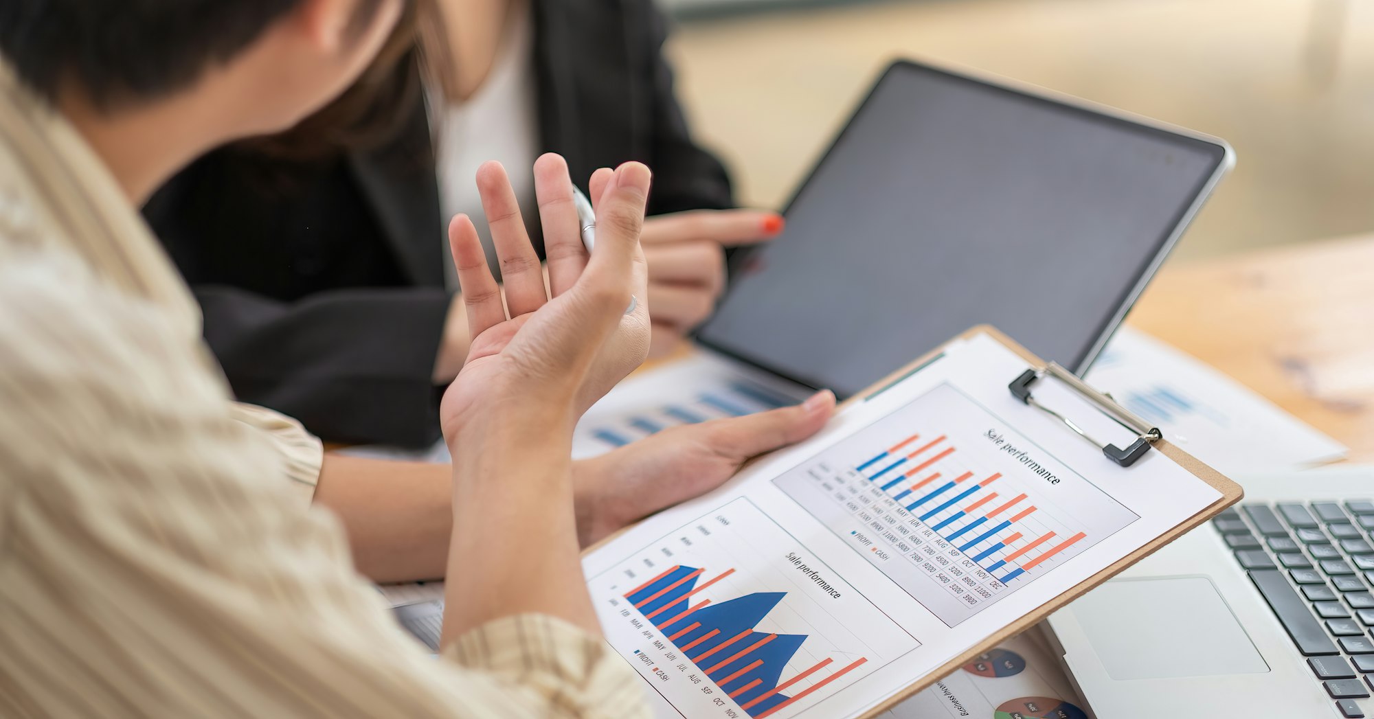 Business people using calculator and laptop computer for discussion about profit, tax, financial