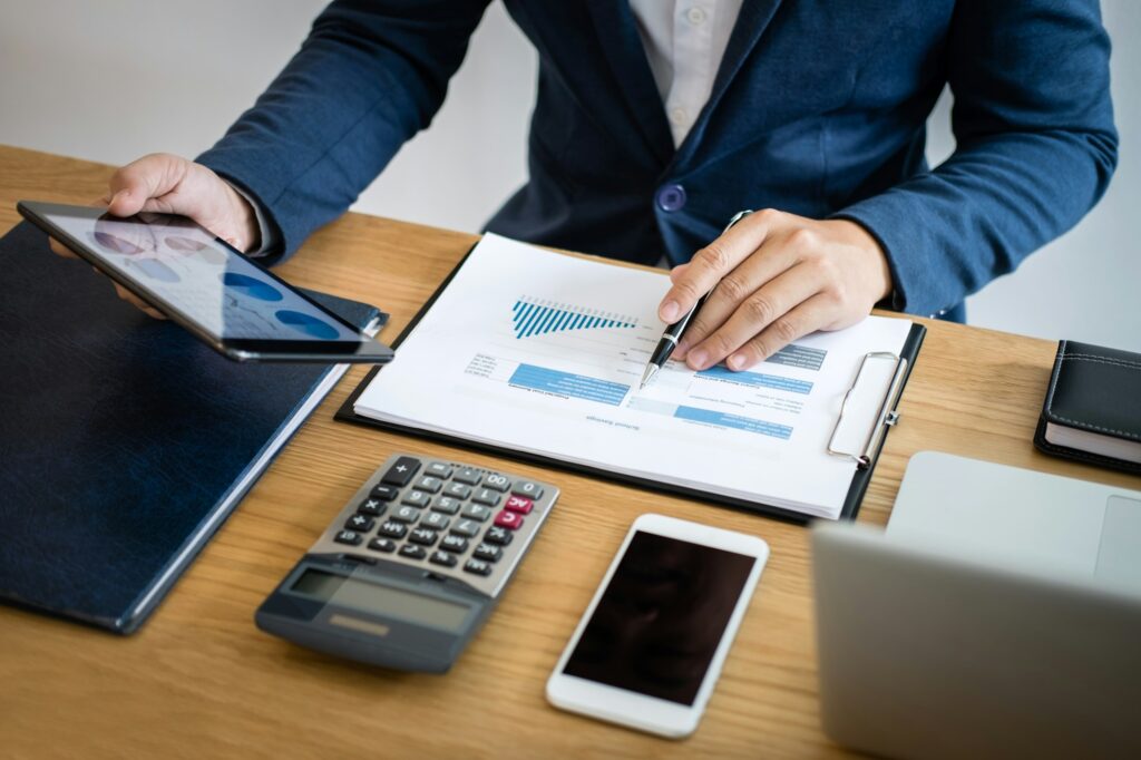 Businessman hands using text information on digital tablet to analyze financial statistical chart