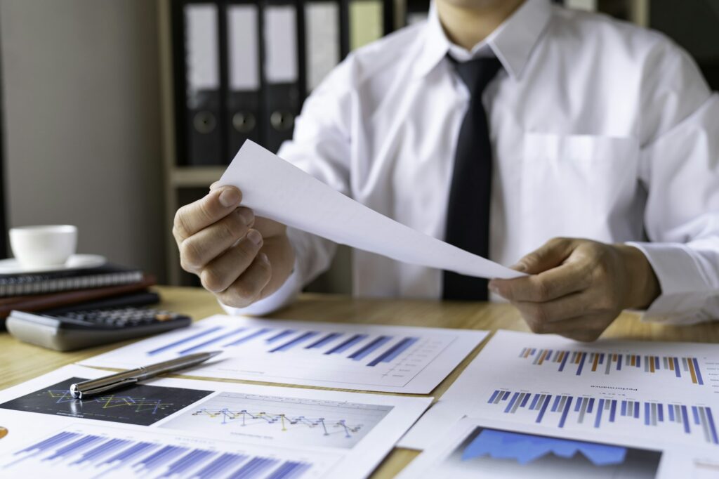 Close-up of businessman's hands collecting bills for tax refund and tax savings, finance banking and